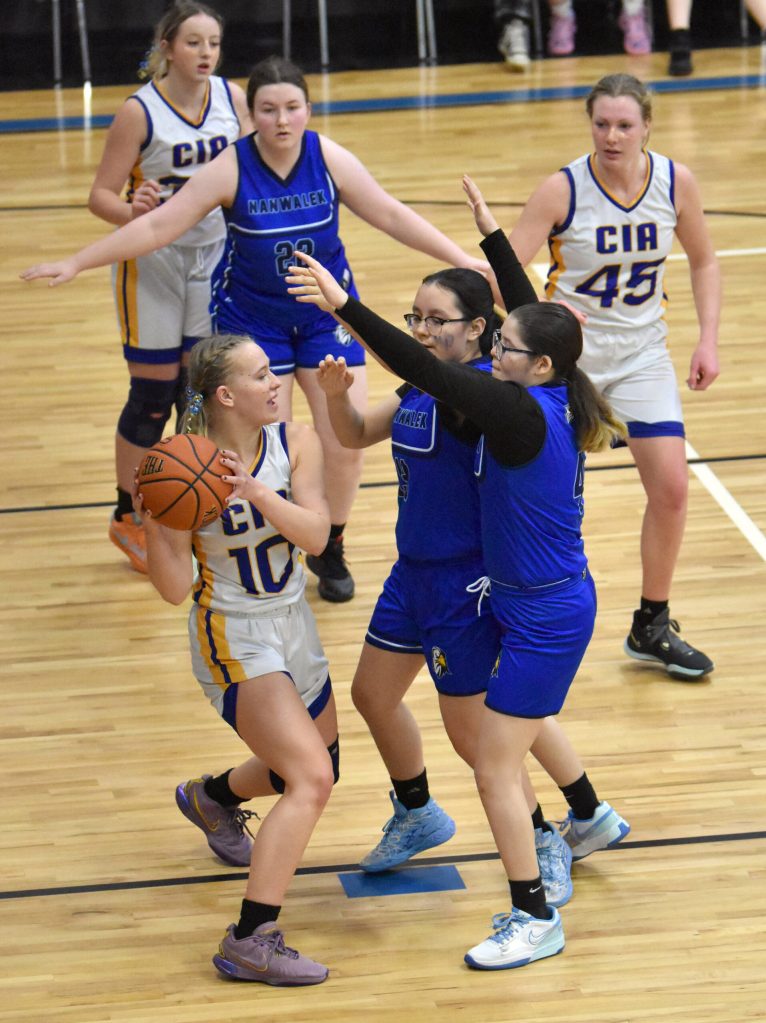 Cook Inlet Academys Kristi Stoll holds the ball under pressure from Nanwaleks Harleigh Romanoff-Moonin and Emma Tanape on Saturday, March 1, 2025, at the Peninsula Conference tournament at Cook Inlet Academy just outside of Soldotna, Alaska. (Photo by Jeff Helminiak/Peninsula Clarion)