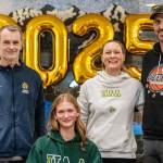 Homer senior Gracie Miotke (seated) committed to run track and field at the University of Alaska Anchorage on Wednesday, March 5, 2025, at Homer High School in Homer, Alaska. Behind Miotke are Homer head coach Bob Ostrom, mother, Amanda Miotke, and father, Dan Miotke. (Photo provided)