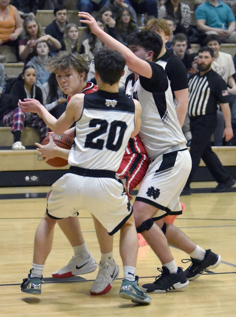 Kenai Centrals Mason Tunseth battles against the trap of Nikiskis Dylan Hall and Kevin Love on Friday, March 7, 2025, at the Peninsula Conference tournament at Nikiski Middle-High School in Nikiski, Alaska. (Photo by Jeff Helminiak/Peninsula Clarion)