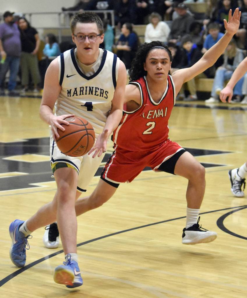 Homers Einar Pederson drives on Kenai Centrals Garrett McCanna on Saturday, March 8, 2025, at the Peninsula Conference tournament at Nikiski Middle-High School in Nikiski, Alaska. (Photo by Jeff Helminiak/Peninsula Clarion)