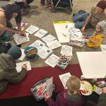 Children and adults color outlines of rainbows and other art during a Unity for the Queer Community event Sunday afternoon at Elizabeth Peratrovich Hall. (Mark Sabbatini / Juneau Empire)