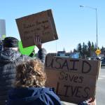 Community members hold up protest signs during the Stand for Democracy Rally on International Womens Day, March 8, 2025, at WKFL Park in Homer, Alaska. (Chloe Pleznac/Homer News)