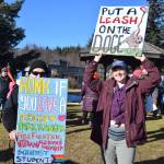 Community members hold up protest signs during the Stand for Democracy Rally on International Womens Day, March 8, 2025, at WKFL Park in Homer, Alaska. (Chloe Pleznac/Homer News)