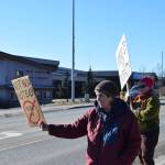 Community members hold up protest signs during the Stand for Democracy Rally on International Womens Day, March 8, 2025 at WKFL Park in Homer, Alaska. (Chloe Pleznac/Homer News)
