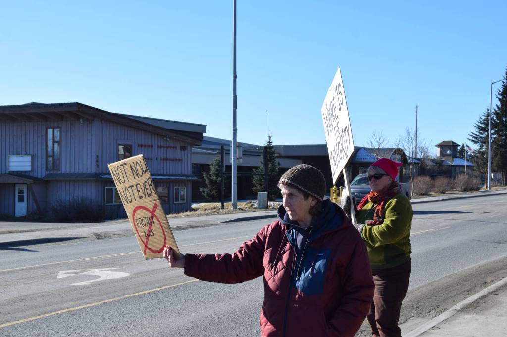 Community members hold up protest signs during the Stand for Democracy Rally on International Womens Day, March 8, 2025 at WKFL Park in Homer, Alaska. (Chloe Pleznac/Homer News)