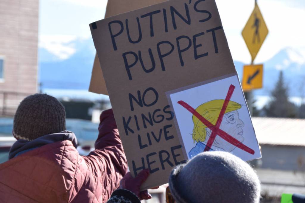 A community member holds up a protest sign during the Stand for Democracy Rally on International Womens Day, March 8, 2025 at WKFL Park in Homer, Alaska. (Chloe Pleznac/Homer News)