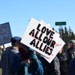 A community member holds up a protest sign during the Stand for Democracy Rally on International Womens Day, March 8, 2025 at WKFL Park in Homer, Alaska. (Chloe Pleznac/Homer News)