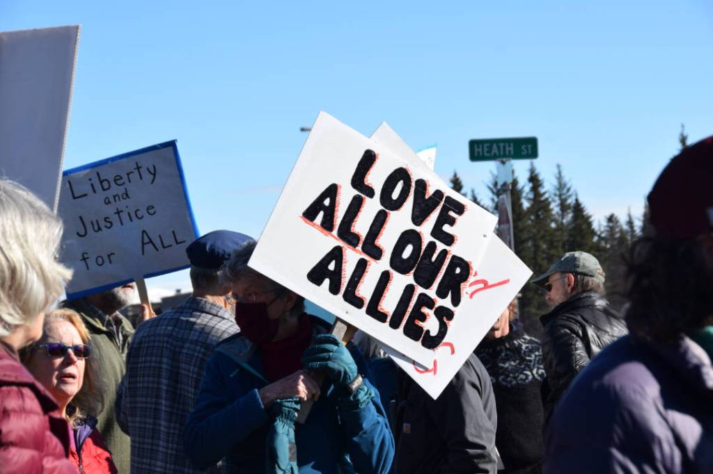 A community member holds up a protest sign during the Stand for Democracy Rally on International Womens Day, March 8, 2025 at WKFL Park in Homer, Alaska. (Chloe Pleznac/Homer News)