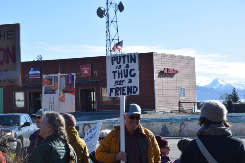 A community member holds up a protest sign during the Stand for Democracy Rally on International Womens Day, March 8, 2025, at WKFL Park in Homer, Alaska. (Chloe Pleznac/Homer News)