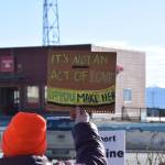 A community member holds up a protest sign during the Stand for Democracy Rally on International Womens Day, March 8, 2025, at WKFL Park in Homer, Alaska. (Chloe Pleznac/Homer News)