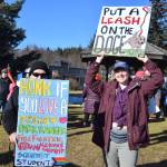 Community members hold up protest signs during the Stand for Democracy Rally on International Womens Day, March 8, 2025, at WKFL Park in Homer, Alaska. (Chloe Pleznac/Homer News)