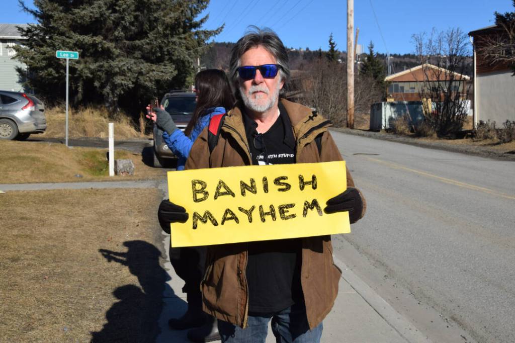 Wes the Mess Shacht holds up a sign during the Stand for Democracy Rally on International Womens Day, March 8, 2025, at WKFL Park in Homer, Alaska. (Chloe Pleznac/Homer News)