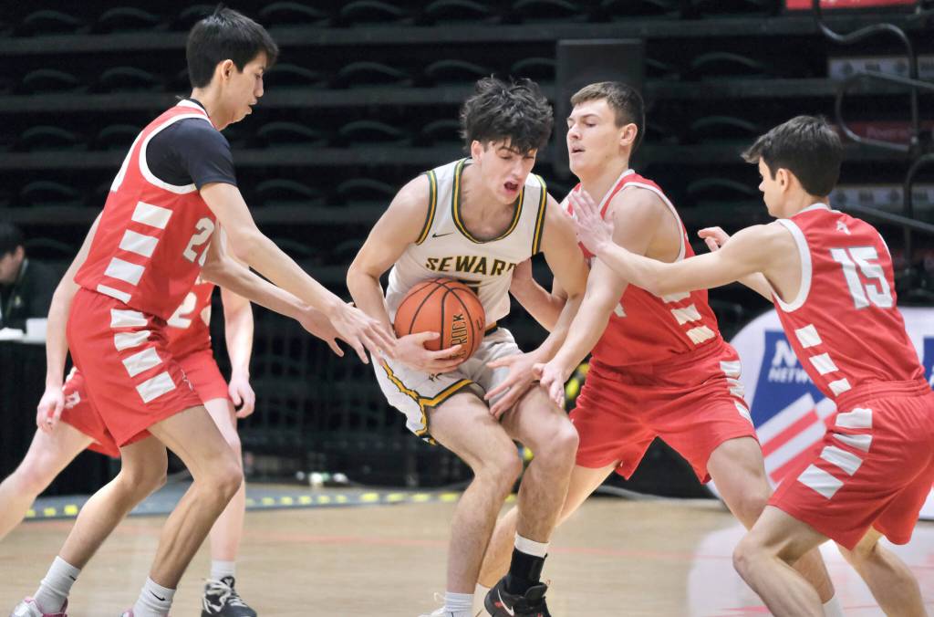 Sewards Van Shank protects the ball from Wrangells Kyan Stead (20), Daniel Harrison and Lucas Schneider (15) during the Seahawks 57-30 win over the Wolves in opening day action at the 2025 ASAA March Madness Alaska 2A State Basketball Championships on Thursday, March 13, 2025, in Anchorages Alaska Airlines Center. (Klas Stolpe / Juneau Empire)