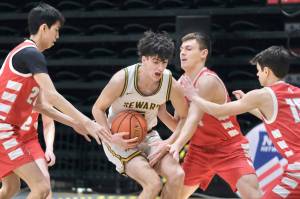 Seward's Van Shank protects the ball from Wrangell's Kyan Stead (20), Daniel Harrison and Lucas Schneider (15) during the Seahawks' 57-30 win over the Wolves in opening day action at the 2025 ASAA March Madness Alaska 2A State Basketball Championships on Thursday, March 13, 2025, in Anchorage's Alaska Airlines Center. (Klas Stolpe / Juneau Empire)