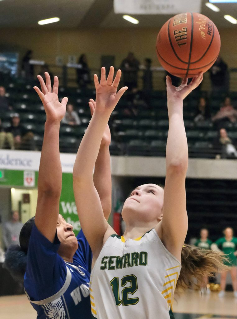Sewards Mikinley Williams (12) scores over Cordovas Yagnnesis Mejias (10) during the Seahawks 49-16 win over the Wolverines in the 2025 ASAA March Madness Alaska 1A/2A State Basketball Championships on Thursday, March 13, 2025, at Anchorages Alaska Airlines Center. (Klas Stolpe / Juneau Empire)