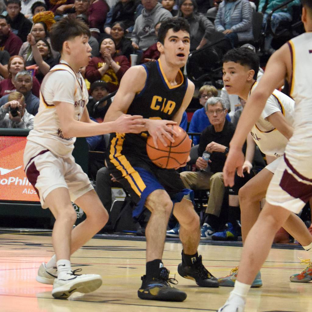 Cook Inlet Academys Ian McGarry drives between Shaktooliks Seth Paniptchuk and Chase Katchatag at the Class 1A boys state championship game Saturday, March 15, 2025, at the Alaska Airlines Center in Anchorage, Alaska. (Photo by Jeff Helminiak/Peninsula Clarion)