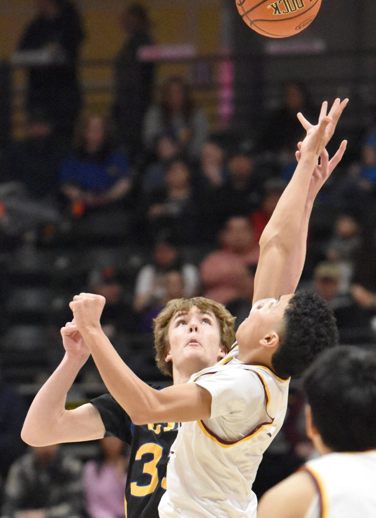 Cook Inlet Academys Brandt Rollman and Shaktooliks Chase Katchatag contest the opening tip at the Class 1A boys state championship game Saturday, March 15, 2025, at the Alaska Airlines Center in Anchorage, Alaska. (Photo by Jeff Helminiak/Peninsula Clarion)