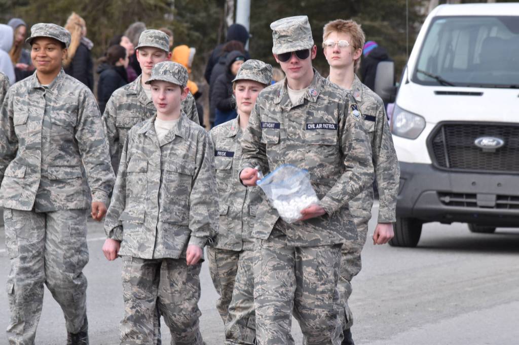 A youth participating in the Civil Air Patrol contingent passes out candy along Fireweed Street during the Sweeneys St. Patricks Day Parade, Monday, March 17, 2025, in Soldotna, Alaska. (Photo by Erin Thompson/Peninsula Clarion)