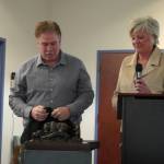 Kenai Mayor Brian Gabriel unveils a small model of the Kenai Bronze Bear Sculpture during a luncheon hosted by the Kenai Chamber of Commerce in Kenai, Alaska, on Wednesday, March 19, 2025. (Jake Dye/Peninsula Clarion)