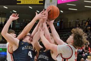 Kenai's Miles Metteer, Homer's Einar Pederson (4) and Henry Wedvik (22) and Kenai's Mason Tunseth (33) battle for a rebound on Thursday, March 20, 2025, in their consolation bracket semifinal during the 2025 ASAA March Madness Alaska 3A/4A Basketball State Championships at the Alaska Airlines Center in Anchorage, Alaska. (Klas Stolpe / Juneau Empire)