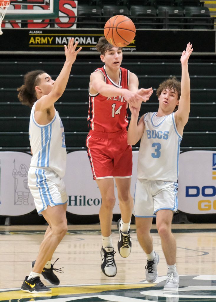 Kenais Miles Metteer (14) passes under pressure from Valdezs Tino Tucker and Jace Branshaw (3) during the Kardinals 71-49 loss to the Buccaneers on Friday, March 21, 2025, in the 4th/6th place game of the 2025 ASAA March Madness Alaska 3A/4A Basketball State Championships at the Alaska Airlines Center in Anchorage, Alaska. (Klas Stolpe / Juneau Empire)