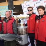 Zach Weimann (left center) poses with his prize-winning fish, previous tournament champions and the championship trophy during the 2025 Homer Winter King Salmon Tournament on Saturday, March 22, 2025, at the Deep Water Dock on the Homer Spit in Homer, Alaska. (Delcenia Cosman/Homer News)