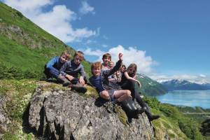 Students smile from atop a mountain peak while engaged in KMTAs Pathfinders program. The program fosters environmental literacy and lifelong learning using an experiential, inquiry-based teaching model and helps expose students to the rich histories, environments and recreation opportunities available in the KMTA. (Photo courtesy of KMTA)