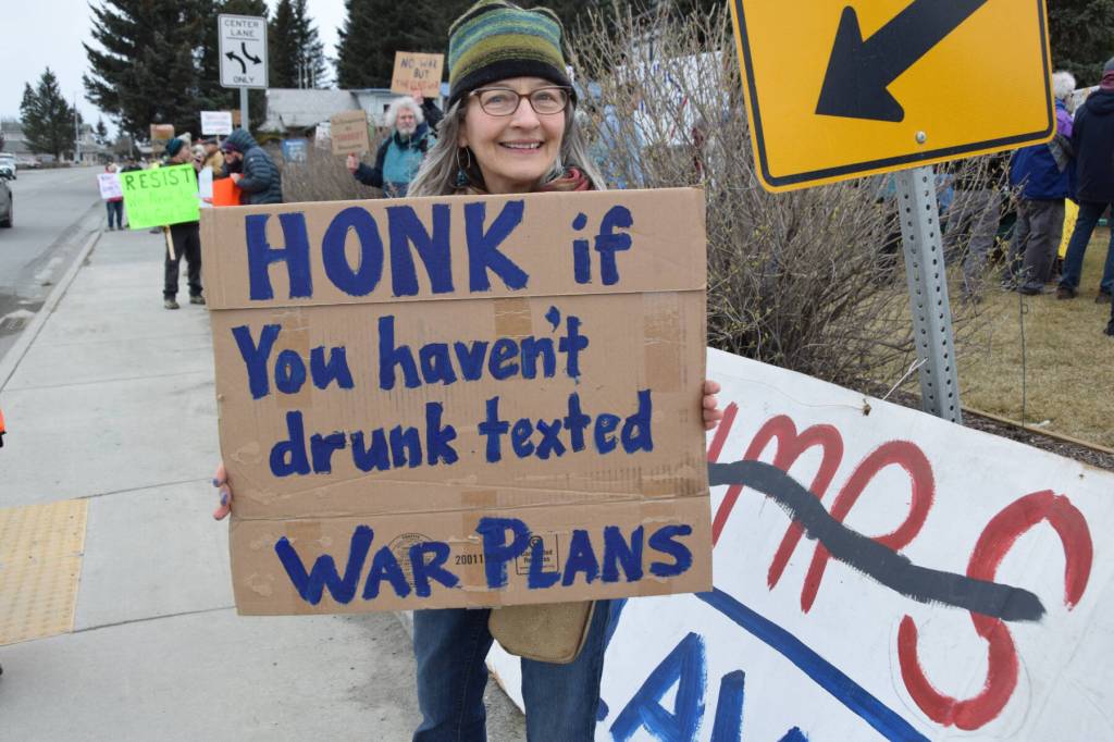 A protester holds up a sign during the nationwide Hands Off! protest on Saturday, April 5 at WKFL Park in Homer, Alaska. (Chloe Pleznac/Homer News)