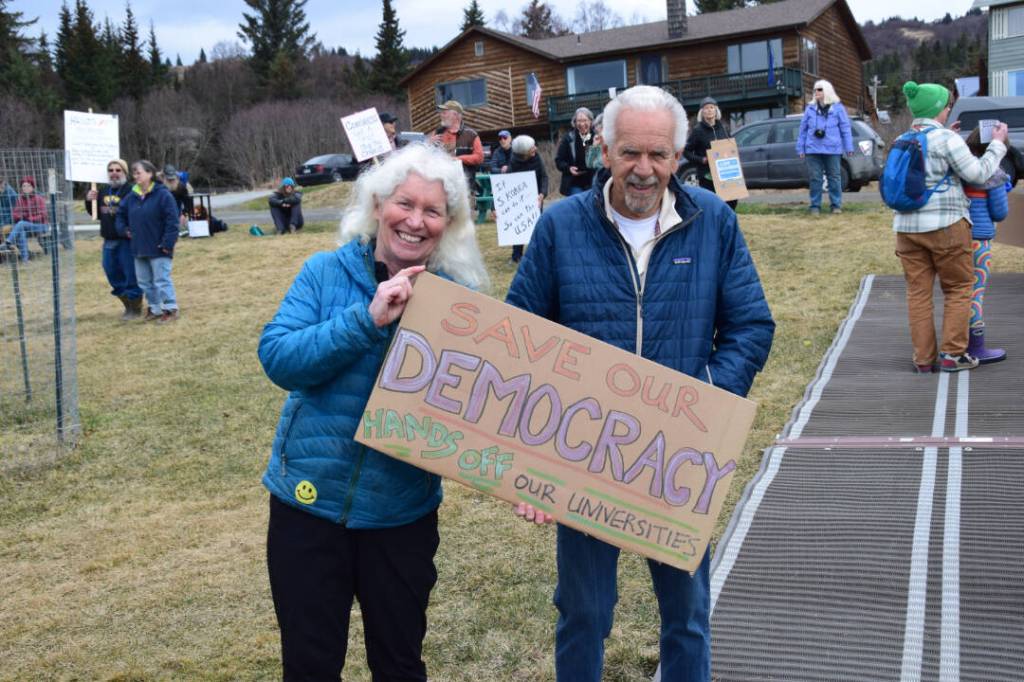 Protesters in Homer hold up a sign during the nationwide Hands Off! protest on Saturday, April 5 at WKFL Park in Homer, Alaska. (Chloe Pleznac/Homer News)