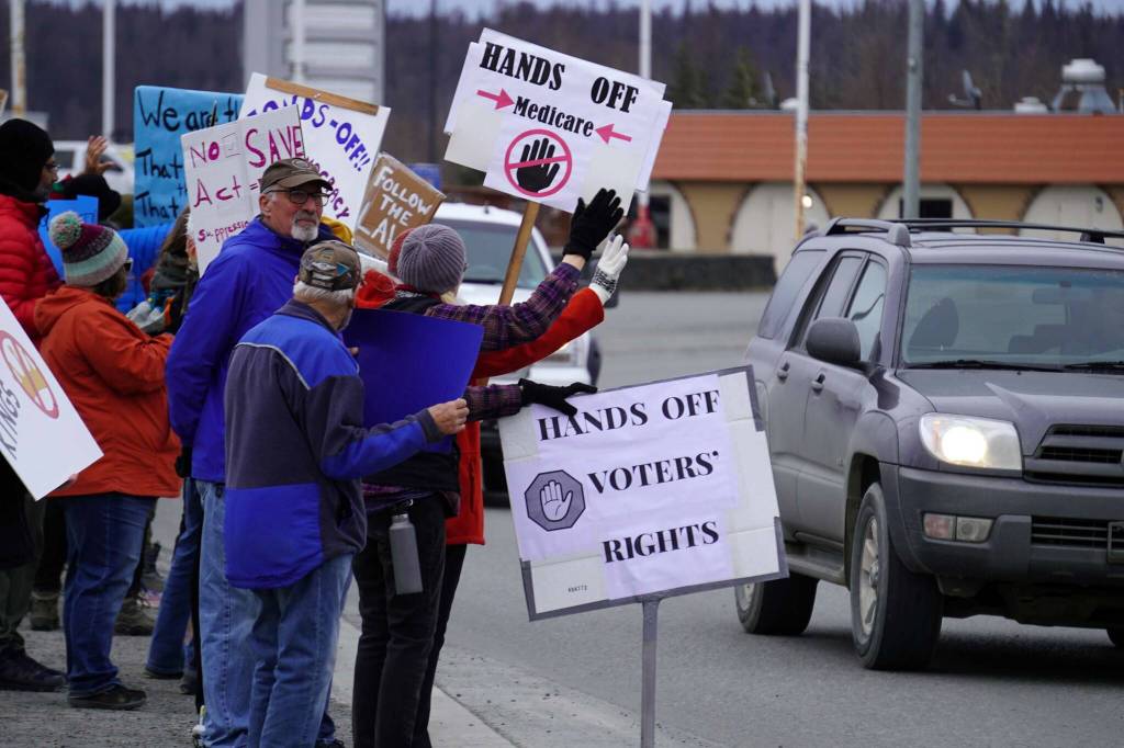 Protesters stand along the Sterling Highway in Soldotna, Alaska, participating in the Remove, Reverse, Reclaim protest organized by Many Voices and Kenai Peninsula Protests as part of the nationwide 50501 effort on Saturday, April 5, 2025. (Jake Dye/Peninsula Clarion)