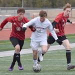 Stone Ausman of Clarkston (Washington) tries to split Sawyer Vann and Zane James of Kenai Central on Monday, April 7, 2025, at Ed Hollier Field at Kenai Central High School in Kenai, Alaska. (Photo by Jeff Helminiak/Peninsula Clarion)