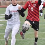 Traysen Hagen of Clarkston (Washington) and Zane James of Kenai Central joust for the ball Monday, April 7, 2025, at Ed Hollier Field at Kenai Central High School in Kenai, Alaska. (Photo by Jeff Helminiak/Peninsula Clarion)