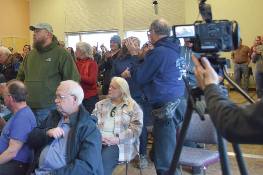 Community members who support education funding stand up in demonstration at one point during the town hall meeting on Saturday, April 12 in the Pioneer Hall at Kachemak Bay Campus. (Chloe Pleznac/Homer News)