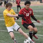 Homers Kai Waltenbaugh shields the ball from Kenai Centrals Enrique Mercado on Thursday, April 17, 2025, at Ed Hollier Field at Kenai Central High School in Kenai, Alaska. (Photo by Jeff Helminiak/Peninsula Clarion)