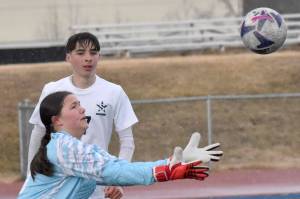 Nikiski's Emily Brannon makes a save in front of Nikiski's Madison Iyatunguk and Soldotna's Lane Hillyer on Tuesday, April 22, 2025, at Justin Maile Field at Soldotna High School in Soldotna, Alaska. (Photo by Jeff Helminiak/Peninsula Clarion)