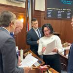 State Sen. Löki Tobin (D-Anchorage) reviews an amendment on an education bill with other senators during a break in floor debate Monday at the Alaska State Capitol. (Mark Sabbatini / Juneau Empire)