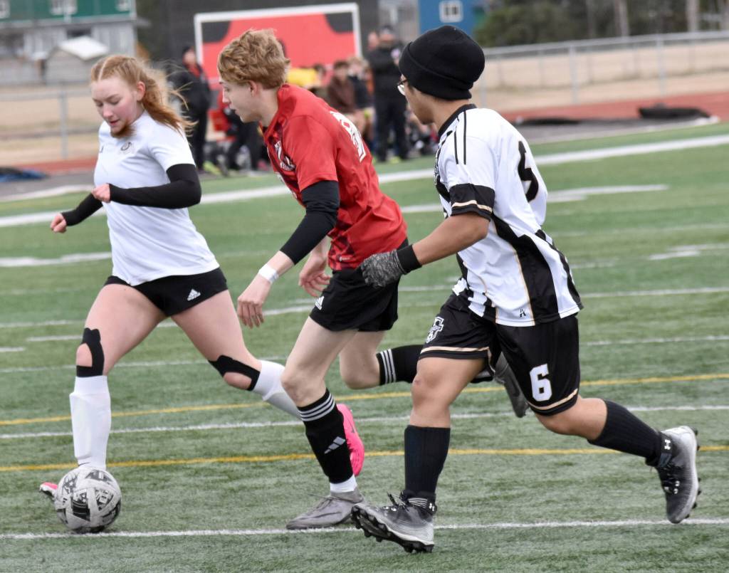 Nikiskis Emma OBrien and Frank Nasibog battle for the ball with Kenai Centrals Zane James on Tuesday, April 29, 2025, at Ed Hollier Field at Kenai Central High School in Kenai, Alaska. (Photo by Jeff Helminiak/Peninsula Clarion)
