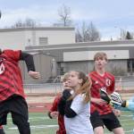 Kenai Central's Diego Huerta heads the ball in front of Nikiski defender Jayden Anderson and goalie Emily Brannen on Tuesday, April 29, 2025, at Ed Hollier Field at Kenai Central High School in Kenai, Alaska. (Photo by Jeff Helminiak/Peninsula Clarion)