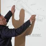 Project Manager Jerrod Stafford, of Western Marine Construction, points to a schematic of the revetment set to be constructed as part of the Kenai River Bluff Stabilization Project while giving an update on the project in Kenai, Alaska, on Wednesday, April 30, 2025. (Jake Dye/Peninsula Clarion)