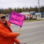 People carry signs and stand as part of a May Day protest alongside the Sterling Highway in Soldotna, Alaska, on Thursday, May 1, 2025. (Jake Dye/Peninsula Clarion)