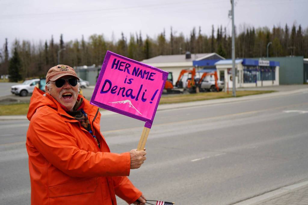 People carry signs and stand as part of a May Day protest alongside the Sterling Highway in Soldotna, Alaska, on Thursday, May 1, 2025. (Jake Dye/Peninsula Clarion)