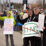 People carry signs and stand as part of a May Day protest alongside the Sterling Highway in Soldotna, Alaska, on Thursday, May 1, 2025. (Jake Dye/Peninsula Clarion)
