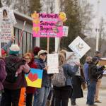 People carry signs and stand as part of a May Day protest alongside the Sterling Highway in Soldotna, Alaska, on Thursday, May 1, 2025. (Jake Dye/Peninsula Clarion)