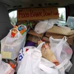 Food donated as part of a May Day protest fills the backseat of a truck alongside the Sterling Highway in Soldotna, Alaska, on Thursday, May 1, 2025. (Jake Dye/Peninsula Clarion)