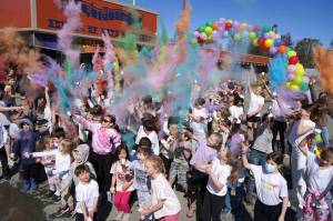 Students throw brightly hued powder into the air during a color run at Kaleidoscope School of Arts and Science in Kenai, Alaska, on Saturday, May 3, 2025. (Jake Dye/Peninsula Clarion)