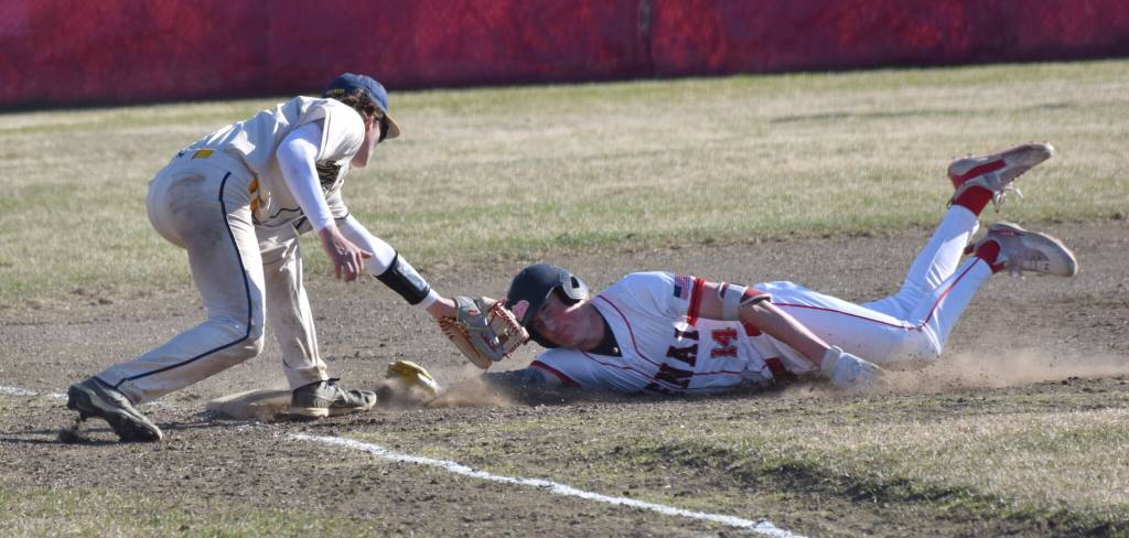 Homer third baseman Weston Marley tags out Kenai Centrals Jacob Joanis at third base Friday, May 9, 2025, at the Kenai Little League fields in Kenai, Alaska. (Photo by Jeff Helminiak/Peninsula Clarion)