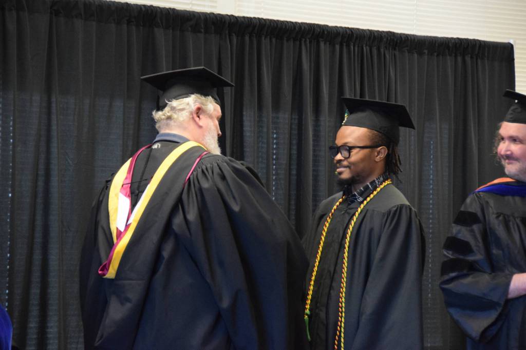 University of Alaska Anchorage graduate Winston Biodun Ajakaye receives his Bachelors in Business Administration degree at the 55th annual commencement ceremony on Wednesday, May 7, 2025, at Kachemak Bay Campus in Homer, Alaska. (Delcenia Cosman/Homer News)