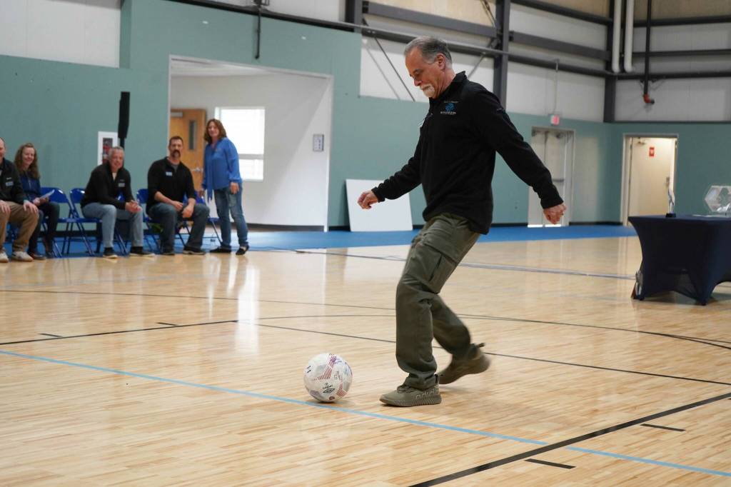 Kenai Peninsula Borough Mayor Peter Micciche kicks a dedicating goal during a ribbon-cutting event for the Boys and Girls Clubs of the Kenai Peninsulas Royce and Melba Roberts Campus in Kenai, Alaska, on Saturday, May 17, 2025. (Jake Dye/Peninsula Clarion)