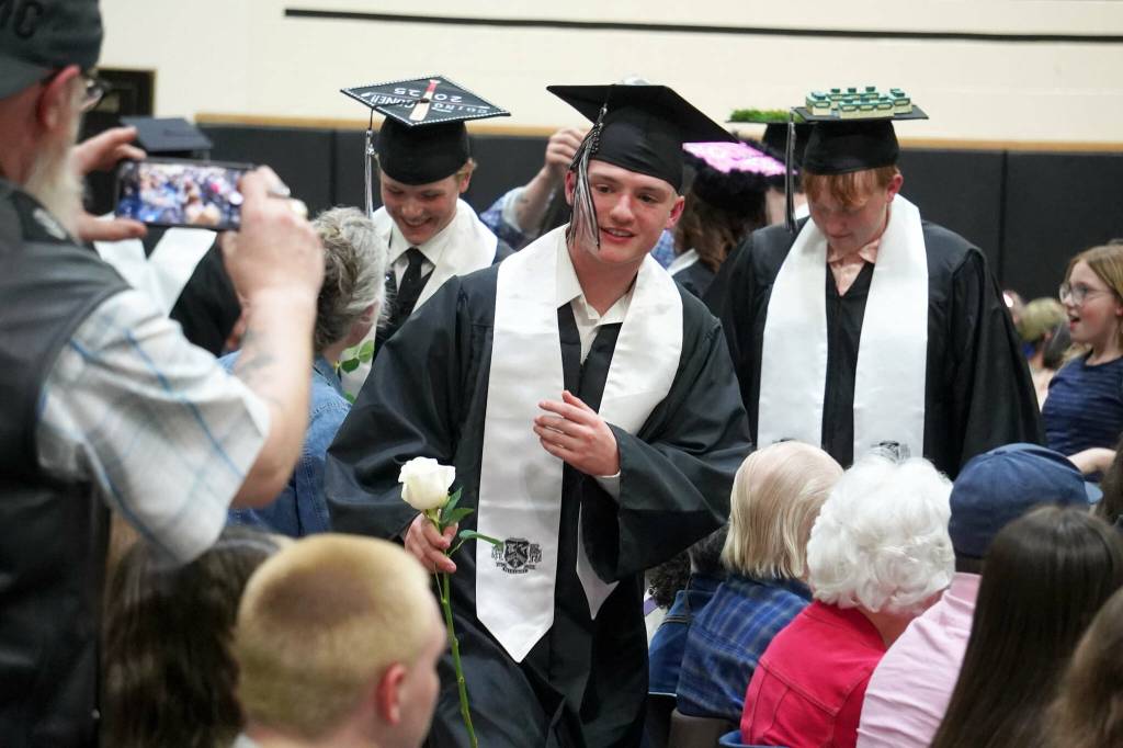 Nikiski senior class president Oliver Parrish brings a rose to one of his supporters during a commencement ceremony at Nikiski/Middle High School in Nikiski, Alaska, on Monday, May 19, 2025. (Jake Dye/Peninsula Clarion)
