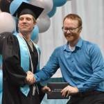 Nicholaus Benkendorf takes command in a grip-strength contest with Principal Shea Nash during the awarding of diplomas at the River City Academy graduation ceremony Tuesday, May 20, 2025, at Skyview Middle School just outside of Soldotna, Alaska. (Photo by Jeff Helminiak/Peninsula Clarion)